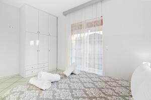 a bedroom with white walls and a bed with white pillows at Minimal Stay House in Petalidi