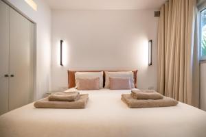 a bedroom with a large white bed with two pillows at The Homega Villa in Il-Madliena