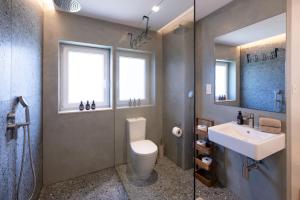 a bathroom with a sink and a toilet and a mirror at The Homega Villa in Il-Madliena
