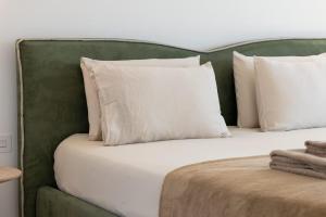a bed with white pillows and a green headboard at The Homega Villa in Il-Madliena +44 photos