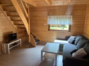 a living room with a couch and a staircase at Agroturystyka i Domki Zacisze in Jarosławiec