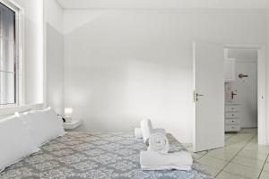 a bedroom with white walls and a bed with towels at Minimal Stay House in Petalidi