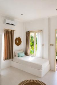 a bed in a room with a window at Villa Norte in Gili Islands