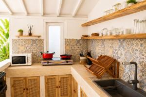 a kitchen with a sink and a microwave at Villa Norte in Gili Islands
