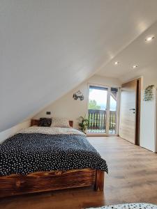 a bedroom with a bed and a large window at Chalet Zasavka in Dol pri Hrastniku