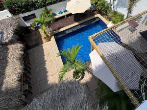 an overhead view of a swimming pool with palm trees and an umbrella at Punta Kai Hotel & Hostal in Puerto Escondido