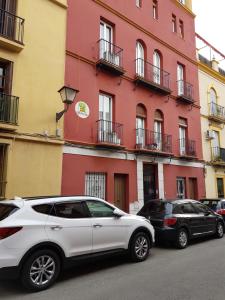 a white car parked in front of a red building at Triana Pureza in Seville