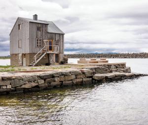 an old house on a dock in the water at Villa Lofoten - The Saltery in Kvalnes
