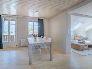 a dining room with a table and chairs and a bed at Mohn in Interlaken