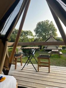 a tent with a picnic table and benches on a deck at São Torpes by Campigir in Sines