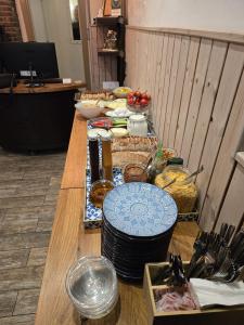 a long wooden table with plates and food on it at Bat Galim Boutique Hotel in Haifa +26 photos