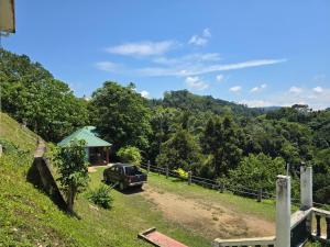 a truck parked on a dirt road in front of a house at D view hill hotel in Kuala Tahan +6 photos