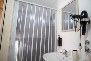 a bathroom with a shower and a sink and a mirror at Ercole B&B in Ugento +13 photos
