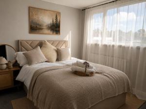 a white bedroom with a bed with a window at Nordic Spa House in Brandon