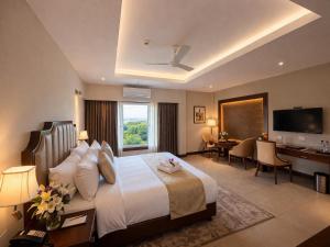 a large hotel room with a bed and a desk at Park Selections in Bhubaneshwar