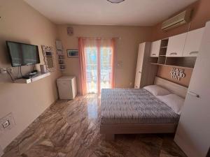 a bedroom with a bed and a television and a window at Apartment Verica in Krilo