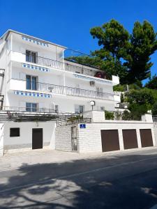 a white building with a fence and a street at Apartment Verica in Krilo