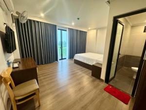 a bedroom with a bed and a desk and a mirror at Family Transit Hotel in Thach Loi