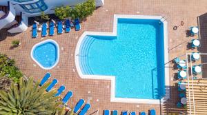 an overhead view of a swimming pool with blue chairs at BLUESEA Jandia Luz in Morro del Jable