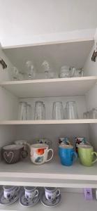 a shelf full of dishes and cups and bowls at Apartman Lavanda in Vrdnik