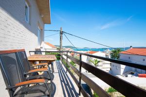 a balcony with chairs and a table and a view of the ocean at Apartment Marin in Tkon