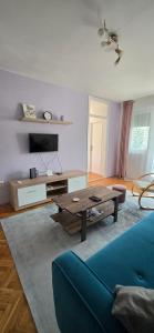 a living room with a blue couch and a table at Apartman Lavanda in Vrdnik