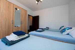 a bedroom with two beds and a cabinet with towels on them at Apartment Marin in Tkon