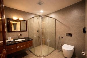 a bathroom with a shower and a toilet and a sink at Park Selections in Bhubaneshwar