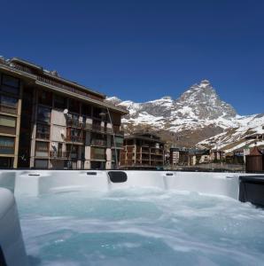 a hot tub with snow capped mountains in the background at Hotel Edelweiss 3 Stelle SUPERIOR in Breuil-Cervinia