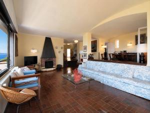 a living room with a large couch and a fireplace at Villa Roberta Pool, wifi & Parking in Arenzano