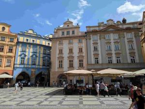 a group of people sitting under umbrellas in a plaza at Astronomical Clock Apartment in Prague