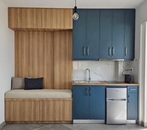 a small kitchen with a bed and blue cabinets at Chilies Rizes in Nafpaktos