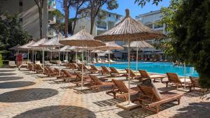 a row of chairs and umbrellas next to a swimming pool at Geri's Beach Apartments in Golem