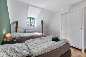 two beds in a room with white walls at Historischer Resthof in Hövede
