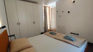 a bedroom with a bed with two towels on it at Chalet al Lac - Cuori - Swimming Pool Como Lake View in Consiglio di Rumo +10 photos