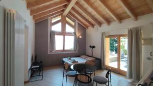 a room with a bed and a table and chairs at Chalet al Lac - Cuori - Swimming Pool Como Lake View in Consiglio di Rumo