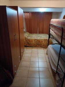 a small room with two beds and a tiled floor at Il Rustico in Celano