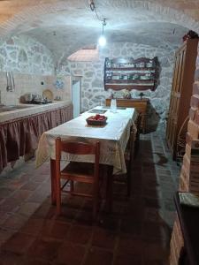 a kitchen with a table in a stone room at Il Rustico in Celano