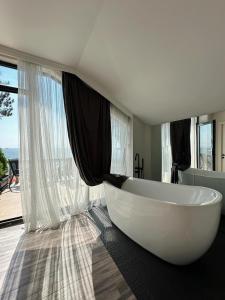 a large white tub in a bathroom with windows at Villa Marnero in Grigoleti +37 photos