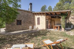 an external view of a house with chairs and a table at Eco Masias Cal Ferran in El Bruc
