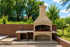 a stone fireplace with a sink in a garden at Magnolia by Briskva in Vinež