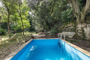 an outdoor swimming pool with trees in the background at Eco Masias Cal Ferran in El Bruc