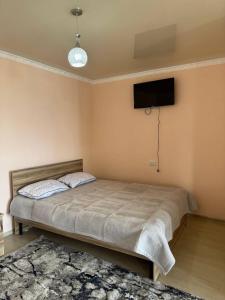 a bedroom with a bed and a tv on the wall at Бархат плюс in Tossor