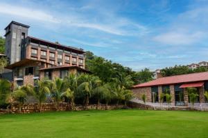 a resort with a lawn in front of a building at The Divine Hills Resort Suites with Private Pool Near IIM Udaipur in Nāi