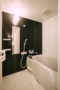 a bathroom with a bath tub and a shower at LIFEMENTGLANZ HOTEL Enomachi in Hiroshima