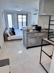 a kitchen with a sink and a couch in a room at LIFEMENTGLANZ HOTEL Enomachi in Hiroshima
