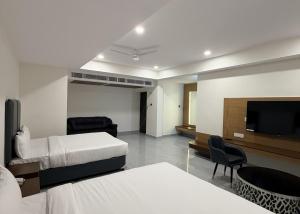 a hotel room with two beds and a flat screen tv at Chhapaak Resort in Patna