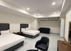 a hotel room with two beds and a chair at Chhapaak Resort in Patna +2 photos