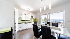 a kitchen with a dining table and a view of the ocean at Villa Antonia by Villas Guide in Blato