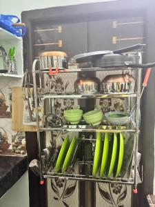 a rack filled with green utensils in a kitchen at Lara Homestay 1bhk Begumpet in Hyderabad +15 photos